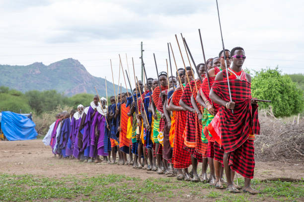 Same, Tanzania, 5th June, 2019: Maasai warriors arriving from a neighboring village in a ceremonial slow walk