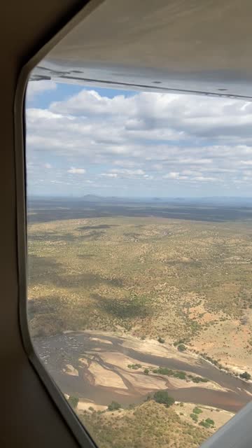 Looking out the window of a small propeller plane while flying over the savanna during dry season in Ruaha National Park in Tanzania, Africa