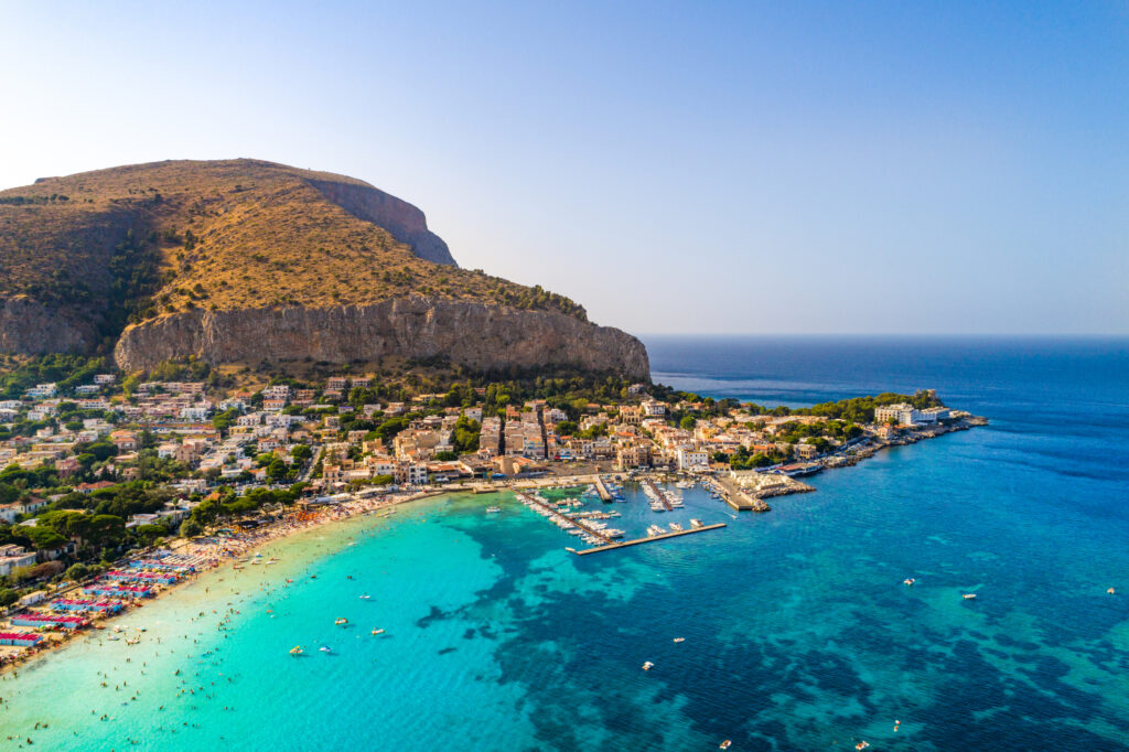 Palermo, Sicily, Italy - August 8, 2017:  view showing Sicily island, boats in the sea, trees, buildings and mountains can be seen on the background