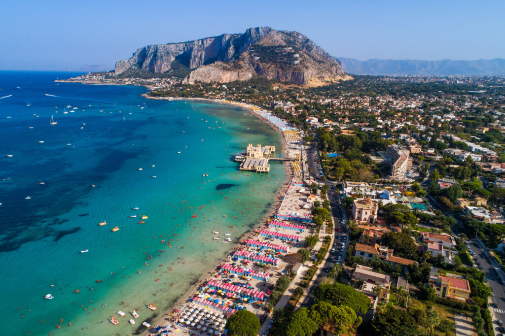 Palermo, Sicily, Italy - August 8, 2017:  view showing Sicily island, boats in the sea, trees, buildings and mountains can be seen on the background