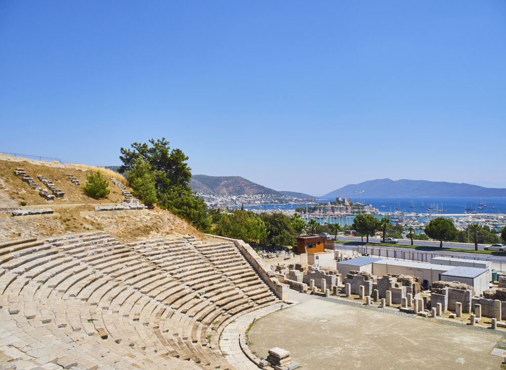 Remains of the Amphitheatre of Halicarnassus with Kumbahce bay and the Castle of Saint Peter in the background. Mugla Province, Turkey.