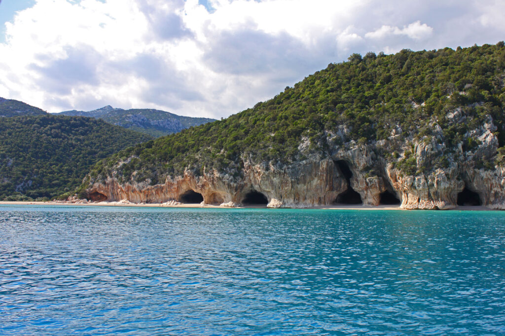 Row of caves at the coast line at Cala Luna beach on Sardinia.