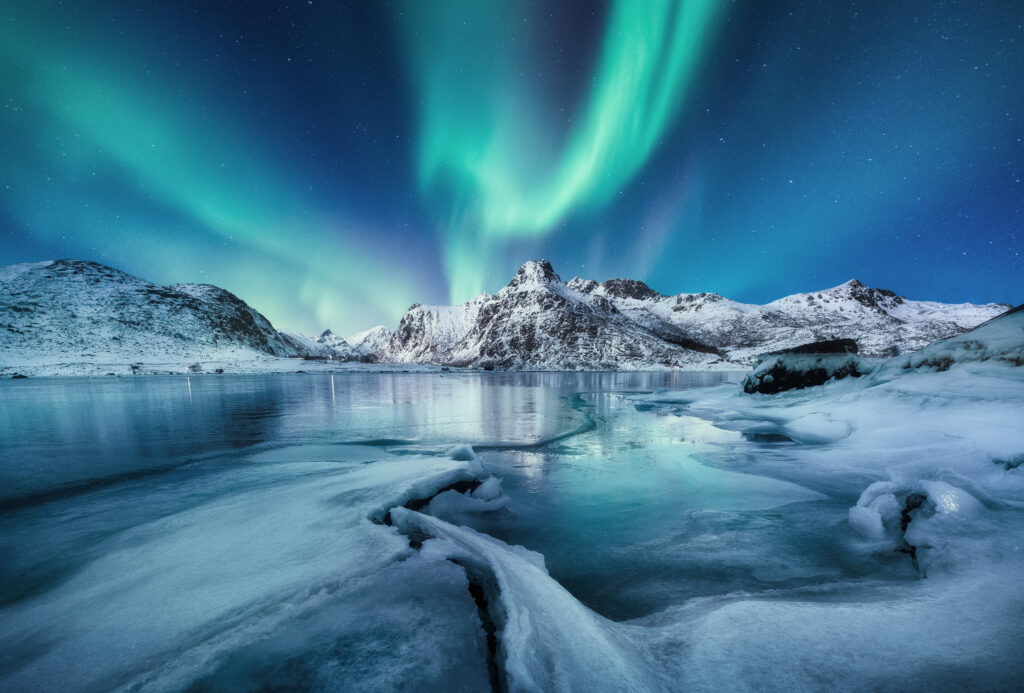 Aurora Borealis, Lofoten islands, Norway. Mountains and frozen ocean. Winter landscape in the night time. Northen lights.