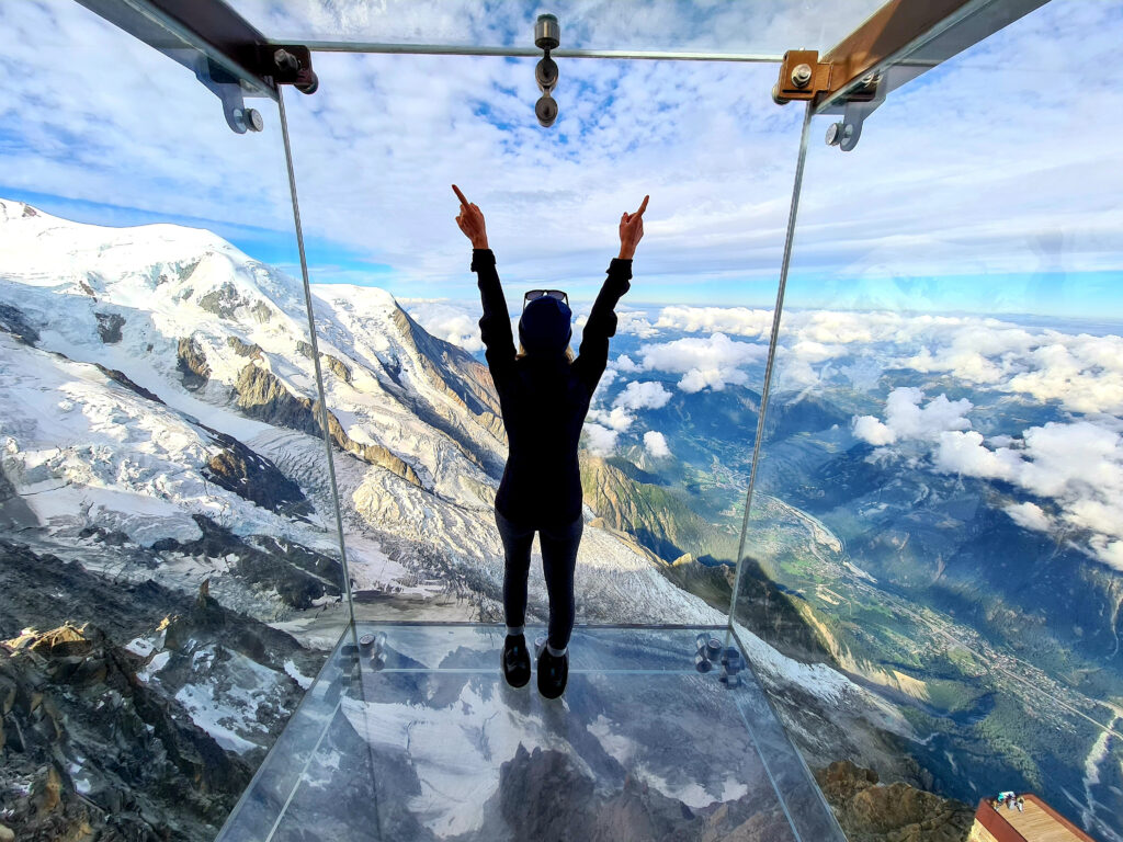 Woman admiring the view from the Glass box suspended over the Chamonix. The Aiguille du Midi. The Aiguille du Midi is a 3,842-metre-tall mountain in the Mont Blanc massif within the French Alps. It is a popular tourist destination and can be directly accessed by cable car from Chamonix that takes visitors close to Mont Blanc. Chamonix needles, Mont Blanc, Haute-Savoie, Alps, France