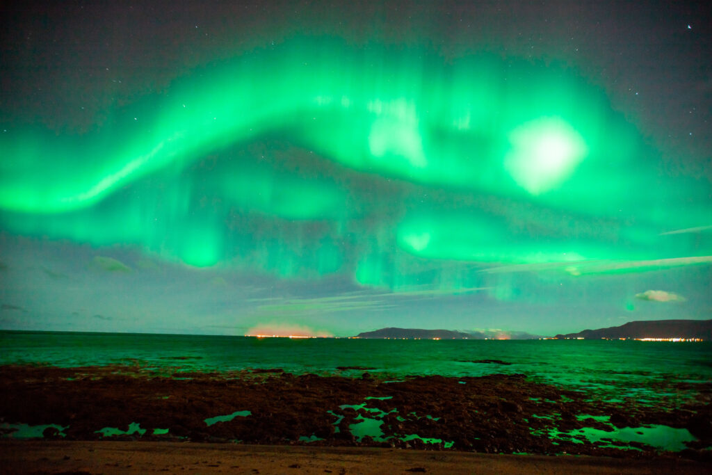 A beautiful shot of the Aurora borealis sky over the snowy field in Iceland, near Reykjavik