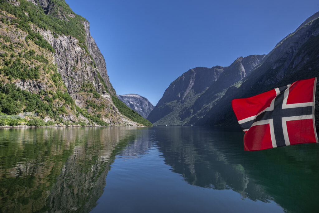 Norwegian flags reflection in Naerøyfjord in Norway