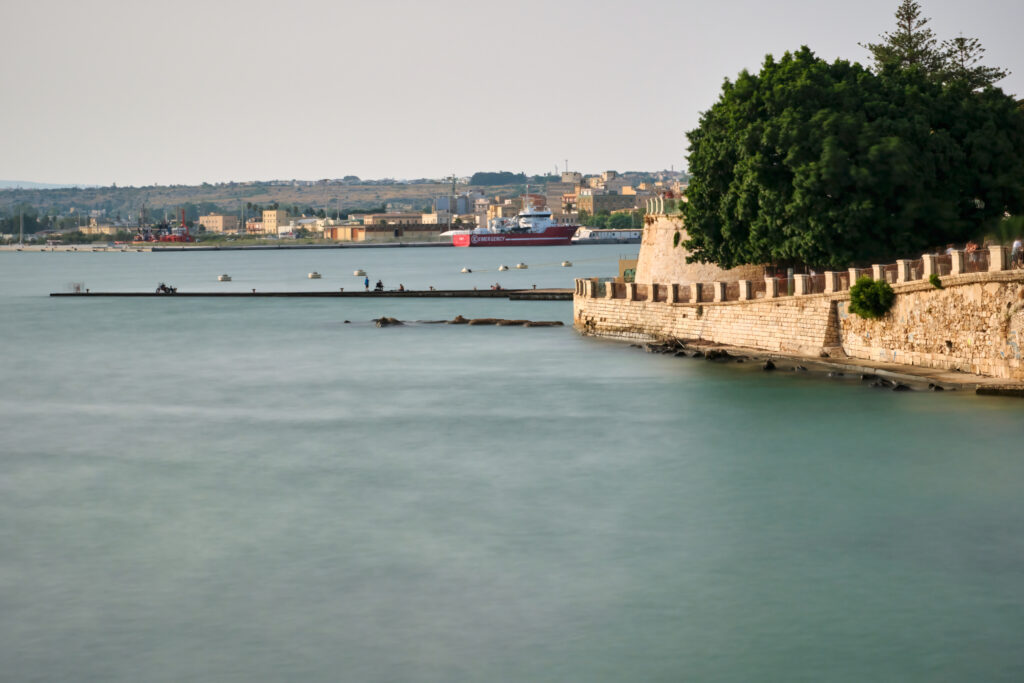 Syracuse, Italy - September 18, 2023: Long Exposure shot of Syracuse main harbor by the famous Arethusa fountain