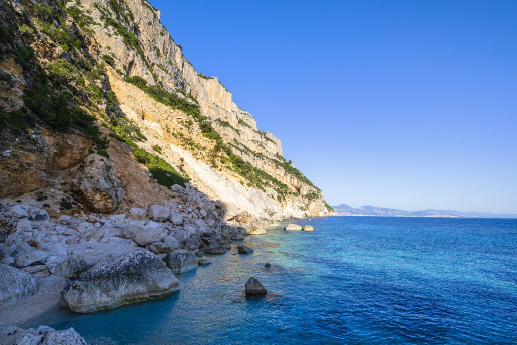 Crystal water laps the Cala Goloritzé, a cove of white small pebbles protected by a rugged cliff