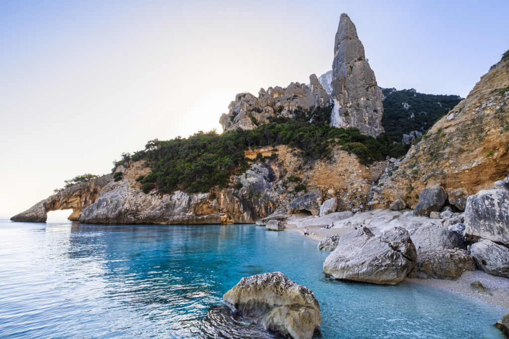 The pyramidal Guglia di Goloritzé watches over the Cala Goloritzé, a cove of white small pebbles lapped by crystal water