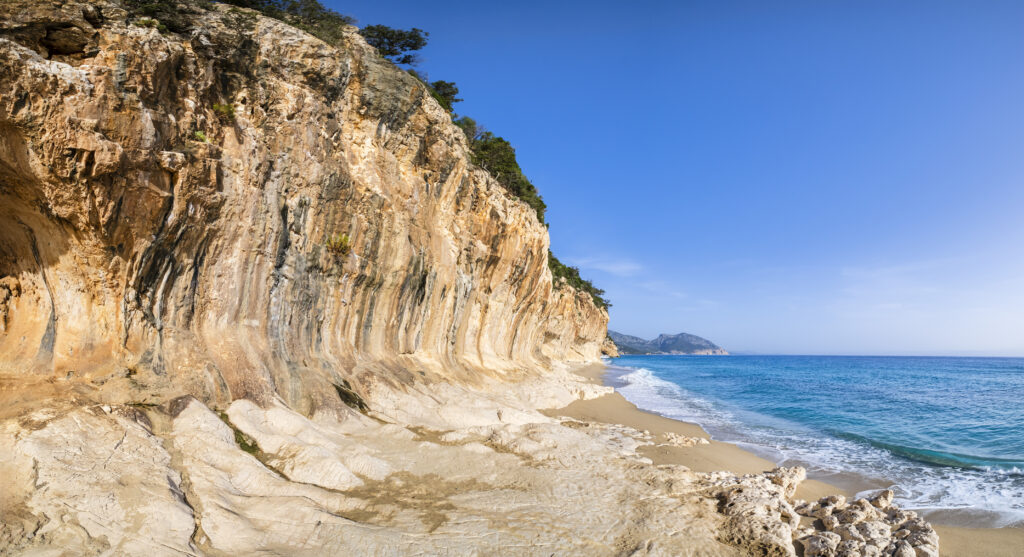 Cala Luna, a remote golden beach in the Gulf of Orosei protected by sheer cliffs dotted with natural caves (7 shots stitched)