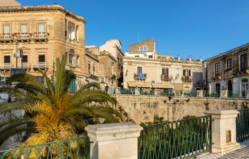 Syracuse, Sicily, Italy - February 16, 2023: Fountain of Arethusa Fonte Aretusa with papyrus plants at Ionian sea shore on ancient Ortigia island of Syracuse historic old town