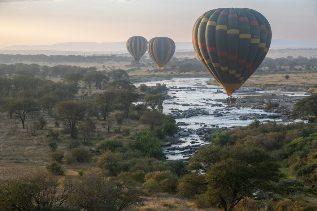 The Mara from above – the Mara River seen from above aboard a hot air balloon with other hot air balloons around, with beautiful morning light at sunrise - Serengeti – Tanzania