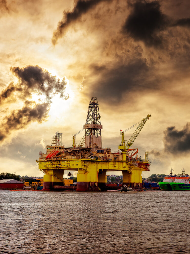 Oil rig moored in the harbor against a dramatic sky.