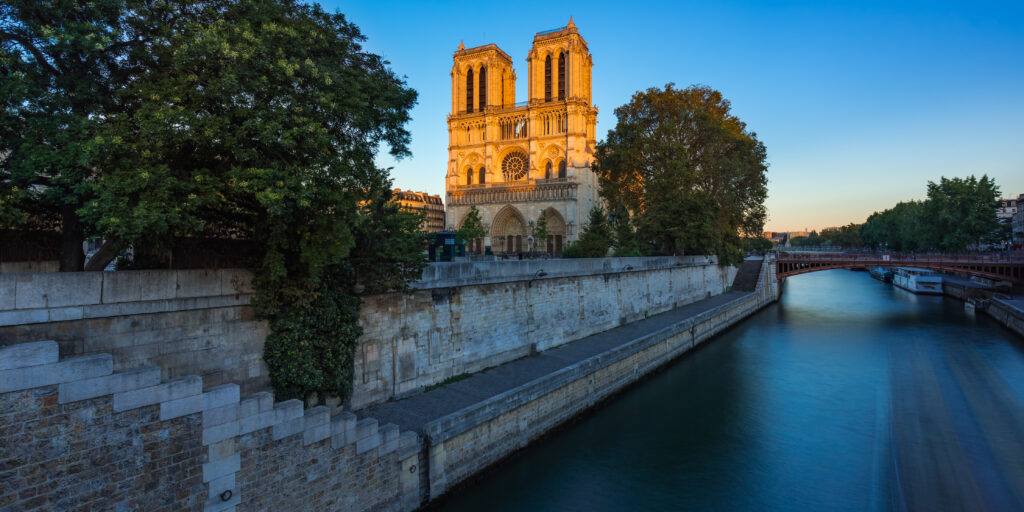 Notre Dame de Paris cathedral on Ile de La Cite at sunset with the Seine River. Summer evening in Paris, France